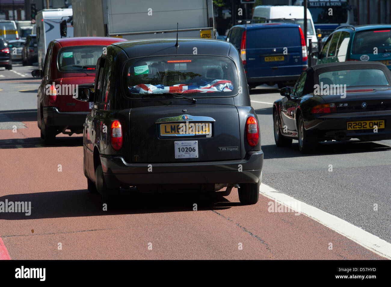 Black taxi cab roulant le long d'une rue dans la ville de Londres, en Angleterre. Banque D'Images