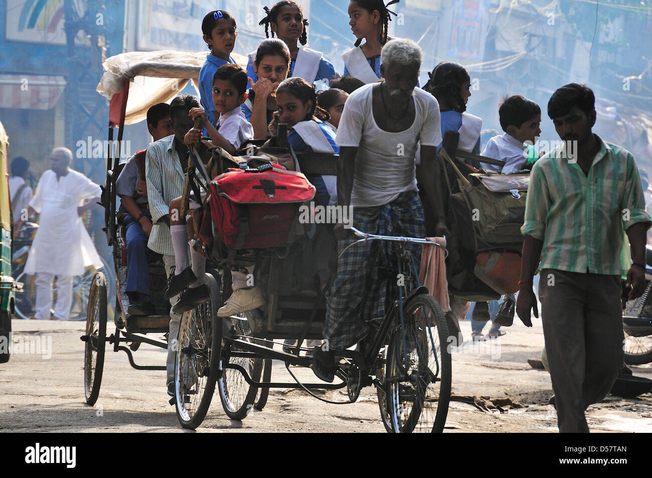 Rickshaw Man d'emmener les enfants à l'école le matin à New Delhi Banque D'Images