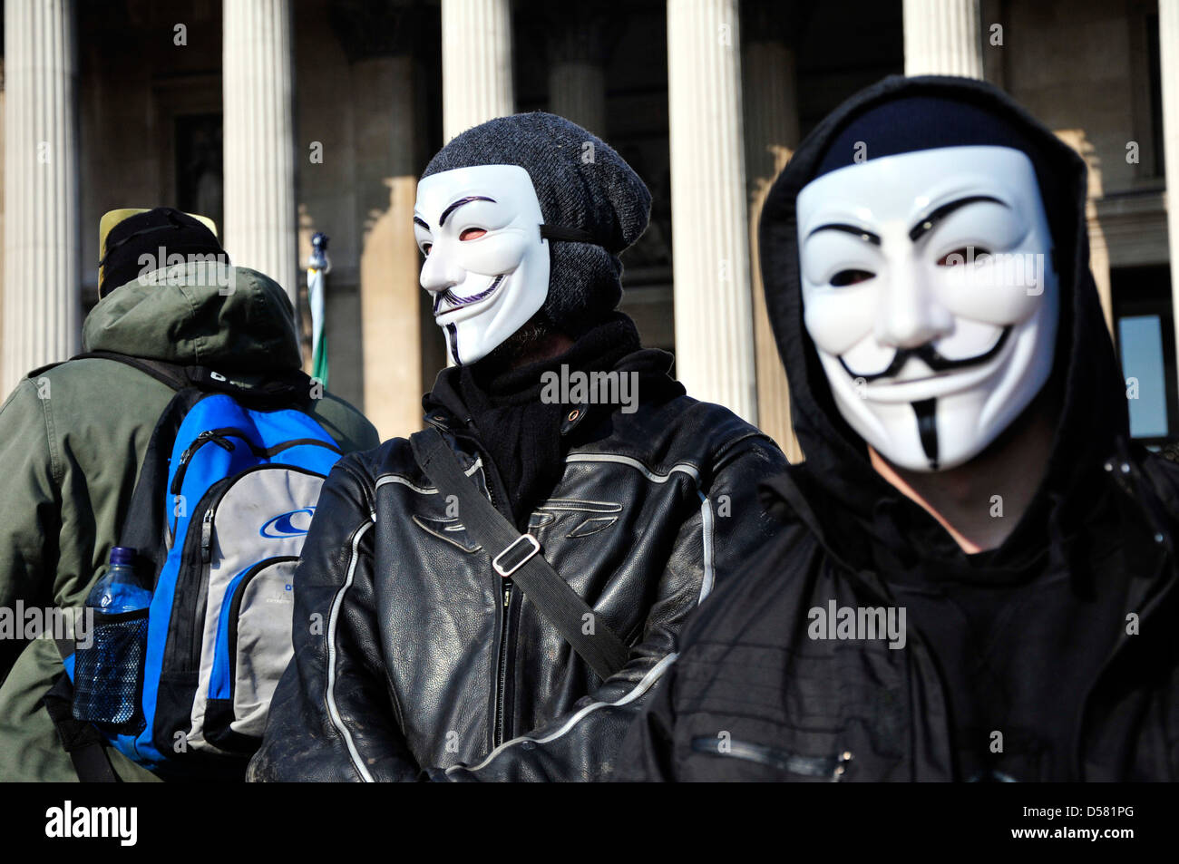 Deux manifestants portant des masques masculins anonyme à un rassemblement à Trafalgar Square, Londres, Royaume-Uni. Banque D'Images