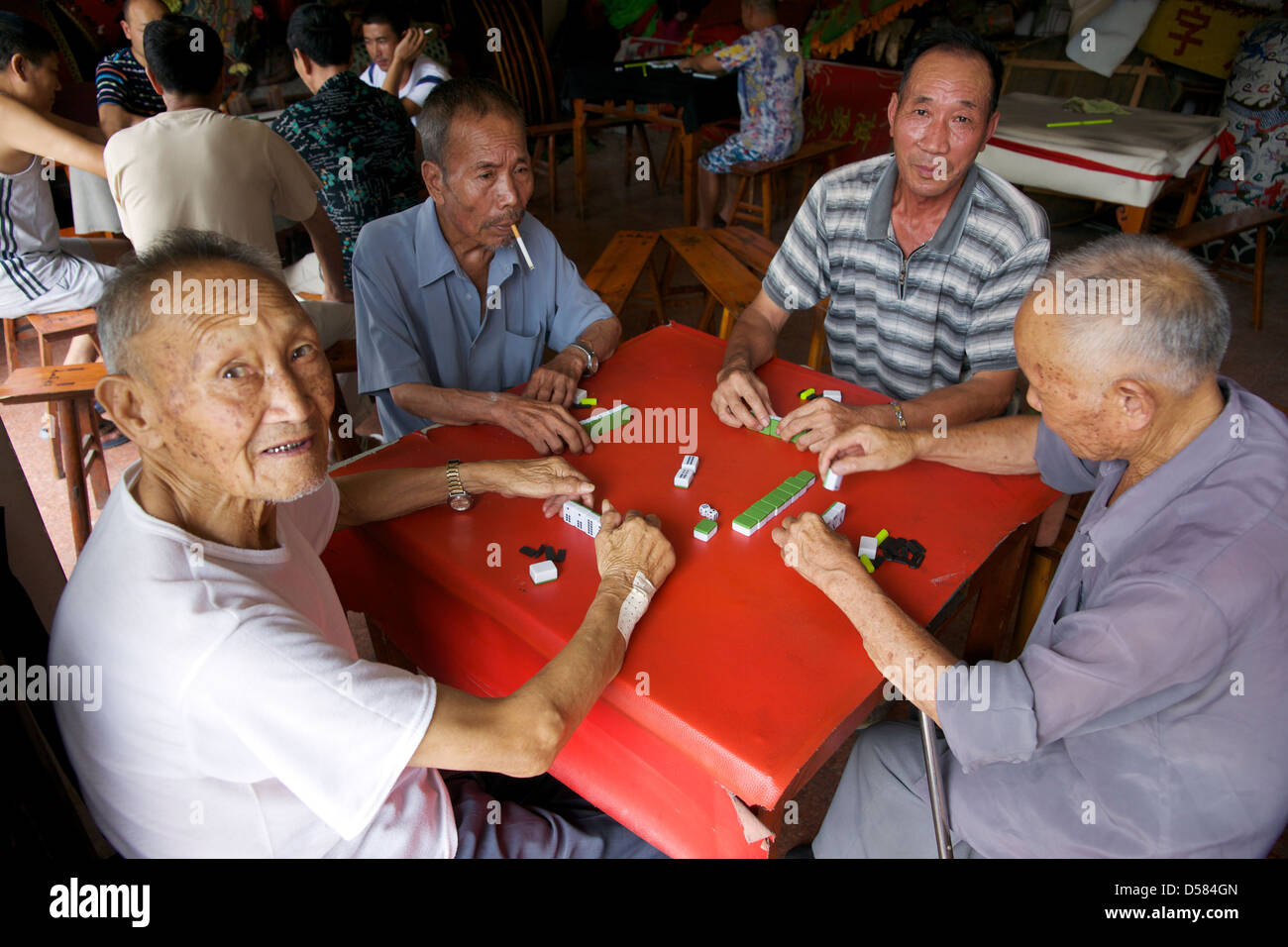 Les hommes jouant le populaire jeu chinois antique de Mahjong dans un temple en Chine. Banque D'Images