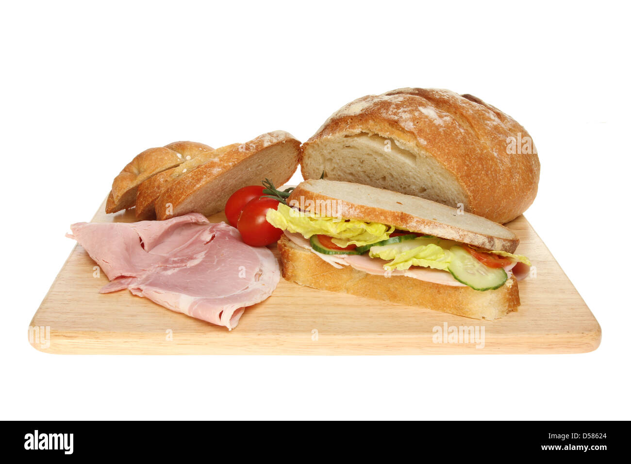 Et de sandwich au jambon pain Bloomer et les tomates sur une planche en bois isolés contre white Banque D'Images