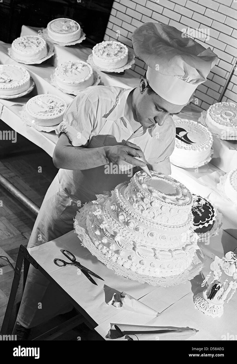 Photographie des employés de Dugan Brothers, une boulangerie et pâtisserie spécialisée dans les gâteaux de mariage, située à long Island, New York. L'image met en valeur le personnel et leurs produits. Banque D'Images