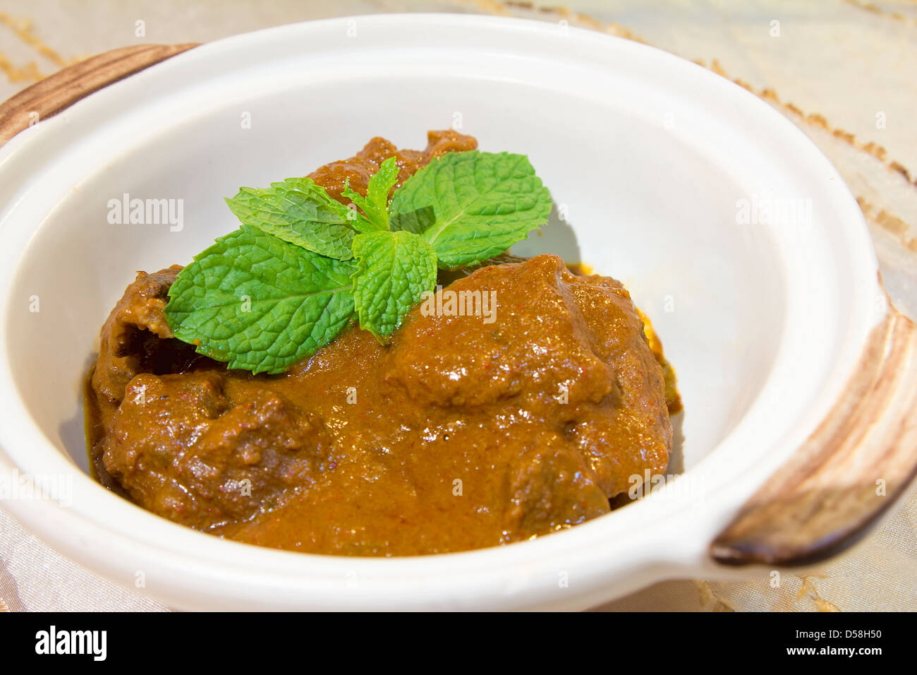 Boeuf au Curry Rendang Nonya Peranakan avec feuilles de menthe garnir closeup Banque D'Images