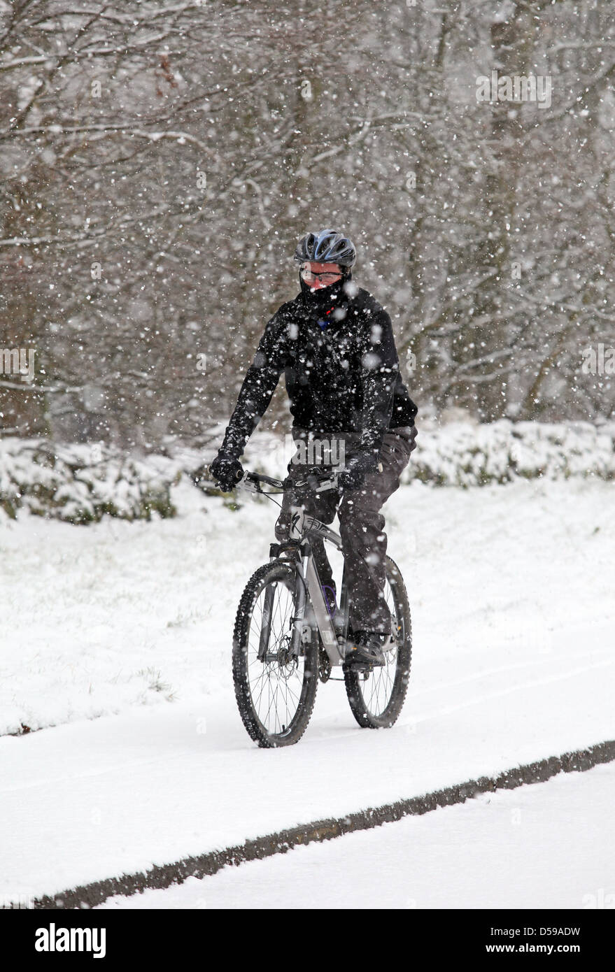 Cycliste à vélo dans la neige lourde au cours de blizzard en Écosse au Royaume-Uni Banque D'Images