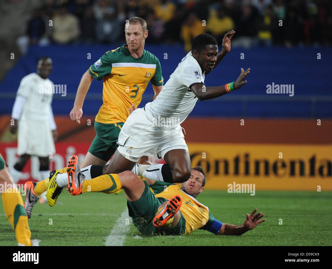 Du Ghana Asamoah Gyan (C) convoite la la balle avec l'Australie, Craig Moore (L) et Lucas Neill durant la Coupe du Monde 2010 GROUPE D match entre le Ghana et l'Australie au Royal Bafokeng Stadium à Rustenburg, Afrique du Sud 19 juin 2010. Photo : Achim Scheidemann - veuillez vous référer à l'http://dpaq.de/FIFA-WM2010-TC Banque D'Images