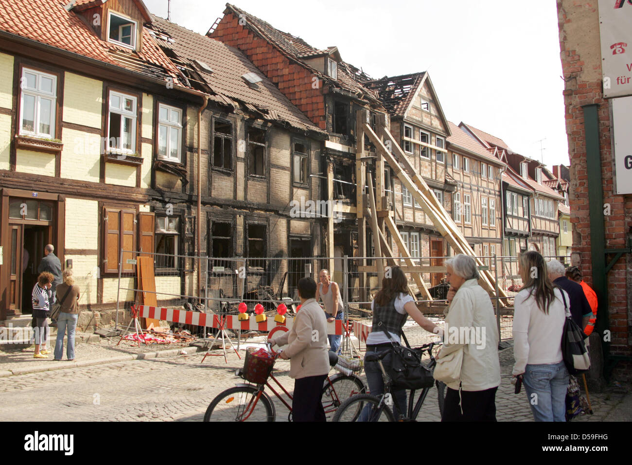 Passants à la destruction de maisons à colombages, consommée par les flammes après un tas de déchets en vrac avait pris feu la nuit précédente à Quedlinburg, Allemagne, le 22 juin 2010. La police a indiqué que la propagation de l'incendie pour les façades, après quoi les maisons brûlées entièrement. Ils sont maintenant en danger de s'effondrer. Un troisième à colombage maison a été endommagée par les flammes. Personne n'a été Banque D'Images