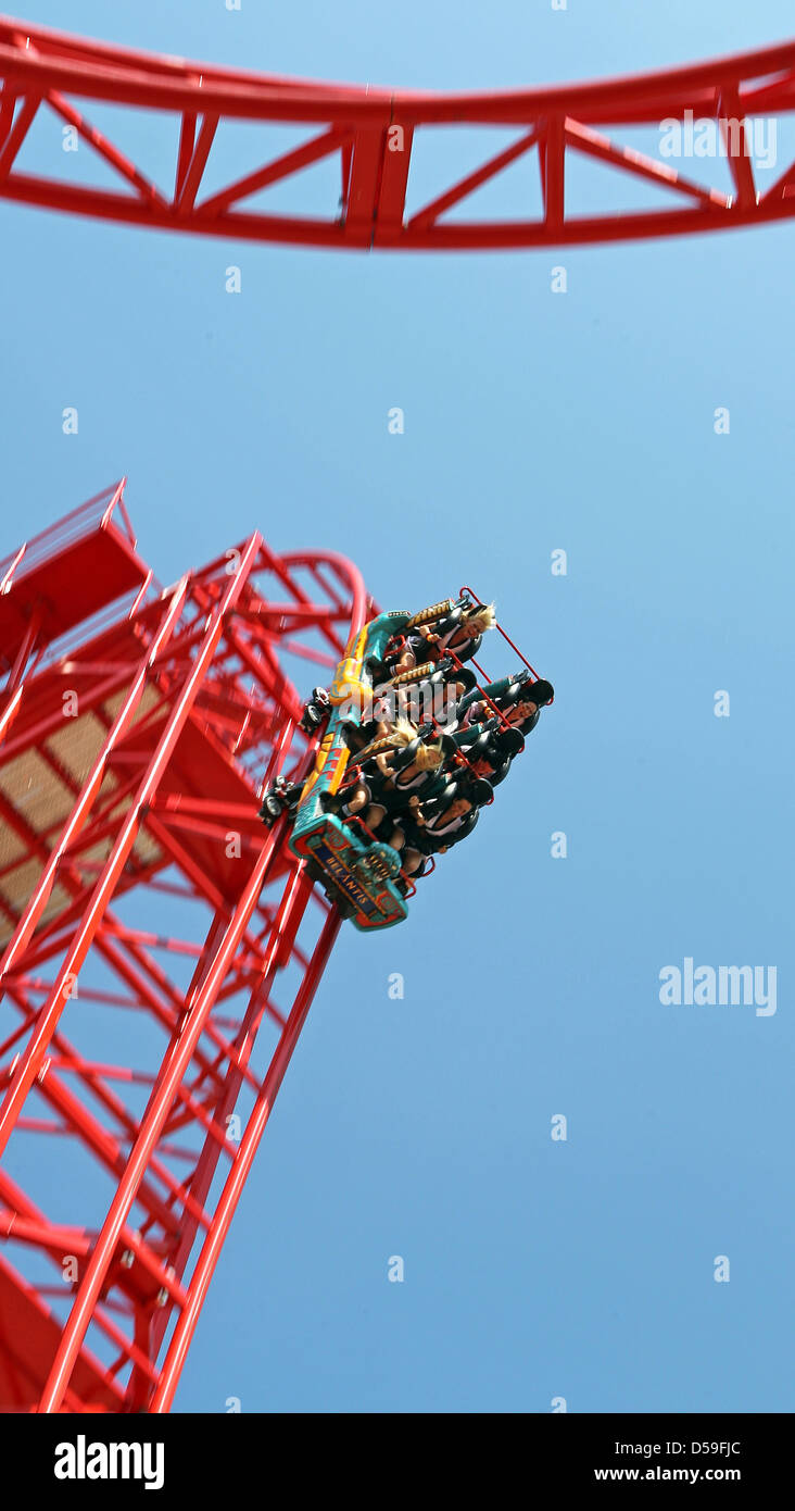 Les visiteurs obtiennent un aperçu de la nouvelle suspension rollercoaster 'Ouragan' au parc d'attractions Belantis à Leipzig, Allemagne, 22 juin 2010. Le rouge vif rollercoaster surprises à ses passagers au départ de la balade avec un effet de chute libre - une chute d'une hauteur de 32 mètres, suivie de cinq boucles. 'Ouragan' le parc a coûté 5 millions d'euros et devrait augmenter son visiteur nu Banque D'Images