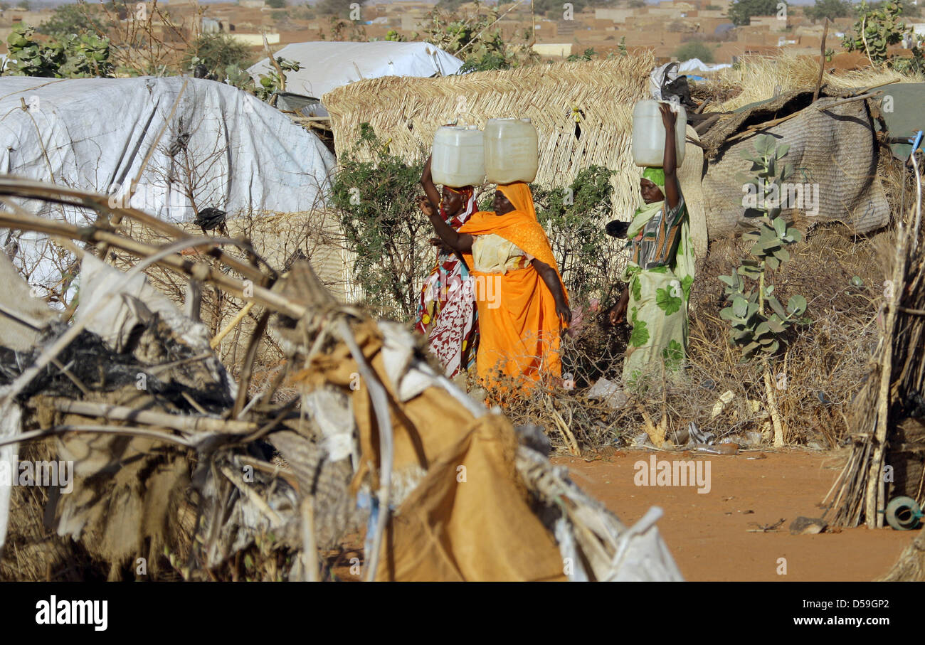 ARCHIV - Drei Frauen sudanesische Flüchtlingslager gehen durch ein in der Stadt Nyala dans le Darfour au Soudan mit im Wasserbehältern auf dem Kopf. (Archivfoto vom 12.12.2007). Lager im leben 35000 Binnenvertriebene. Die beiden dans westsudanesischen Krisenregion entführten Darfour der Mitarbeiter des Technischen Hilfswerks (THW) kommen aus Berlin und Schleswig-Holstein. Die beiden 34 und 52 Banque D'Images