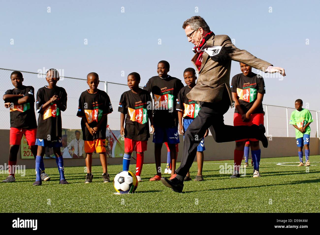 Le ministre allemand de l'intérieur Thomas de Maizière tire un coup de pied de pénalité vu par les jeunes joueurs de football de l'Afrique du Sud lors de l'ouverture d'un terrain de football à l'Orange Farm township, à environ 30km au sud de Johannesburg, Afrique du Sud, le 27 juin 2010. De Maizière est sur une visite de trois jours en Afrique du Sud. Photo : Kerim Okten  + + +(c) afp - Bildfunk + + + Banque D'Images