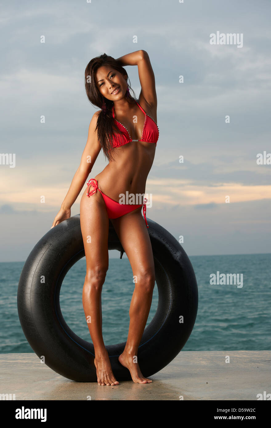 Belle, happy Asian model wearing red bikini sur la plage de Thaïlande avec  tube de pneu Photo Stock - Alamy