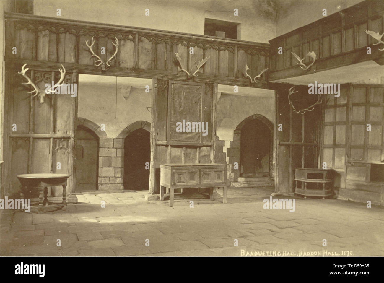 La salle de banquet de Haddon Hall, Derbyshire, Angleterre, est représentée sur cette image. La salle, célèbre pour son intérieur grandiose et ses lustres en bois, est un exemple clé de l'architecture anglaise Tudor. Banque D'Images