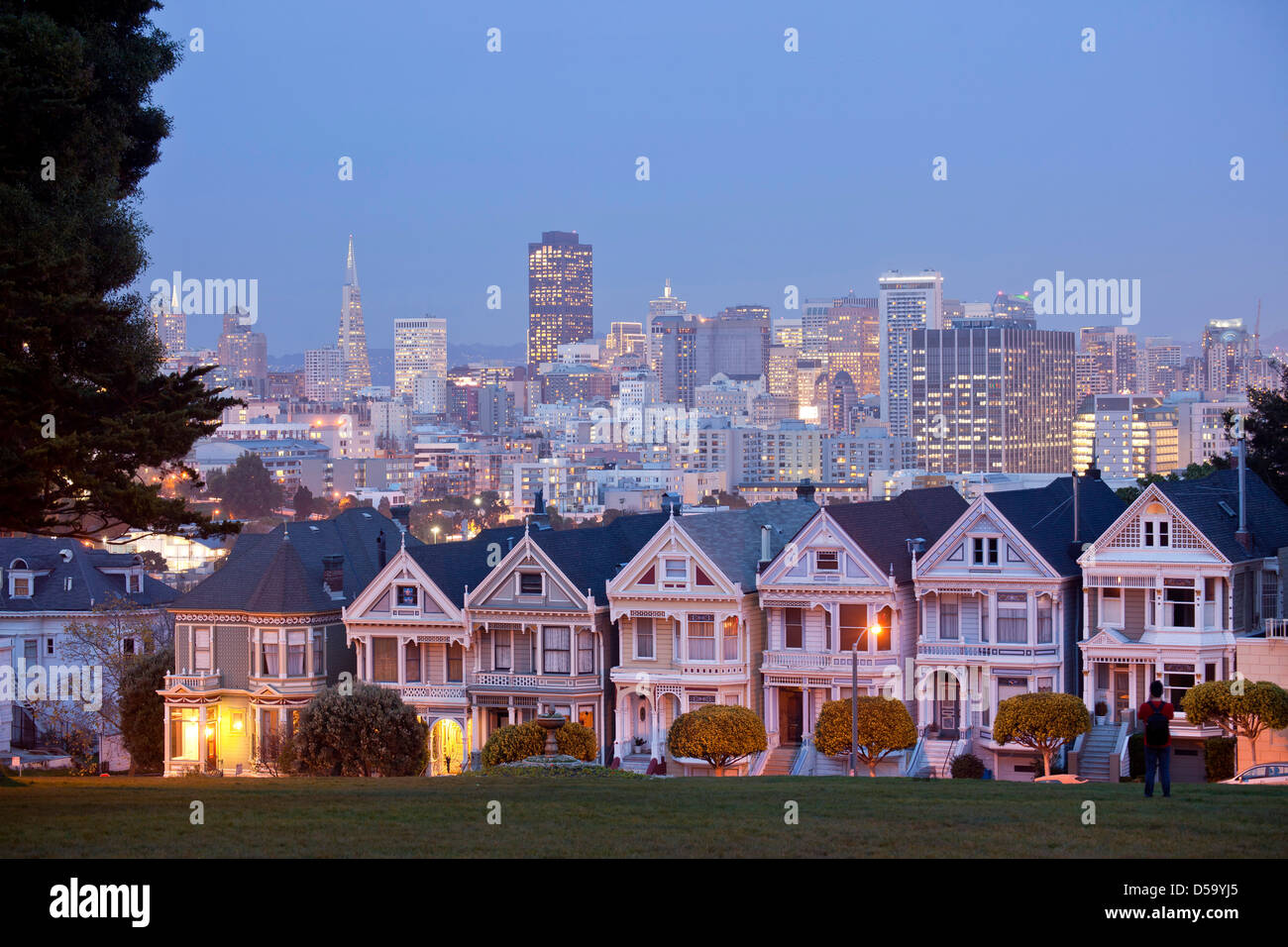 Maisons victoriennes belles dames à Alamo Square et la skyline de San Francisco, Californie, dans la nuit Banque D'Images