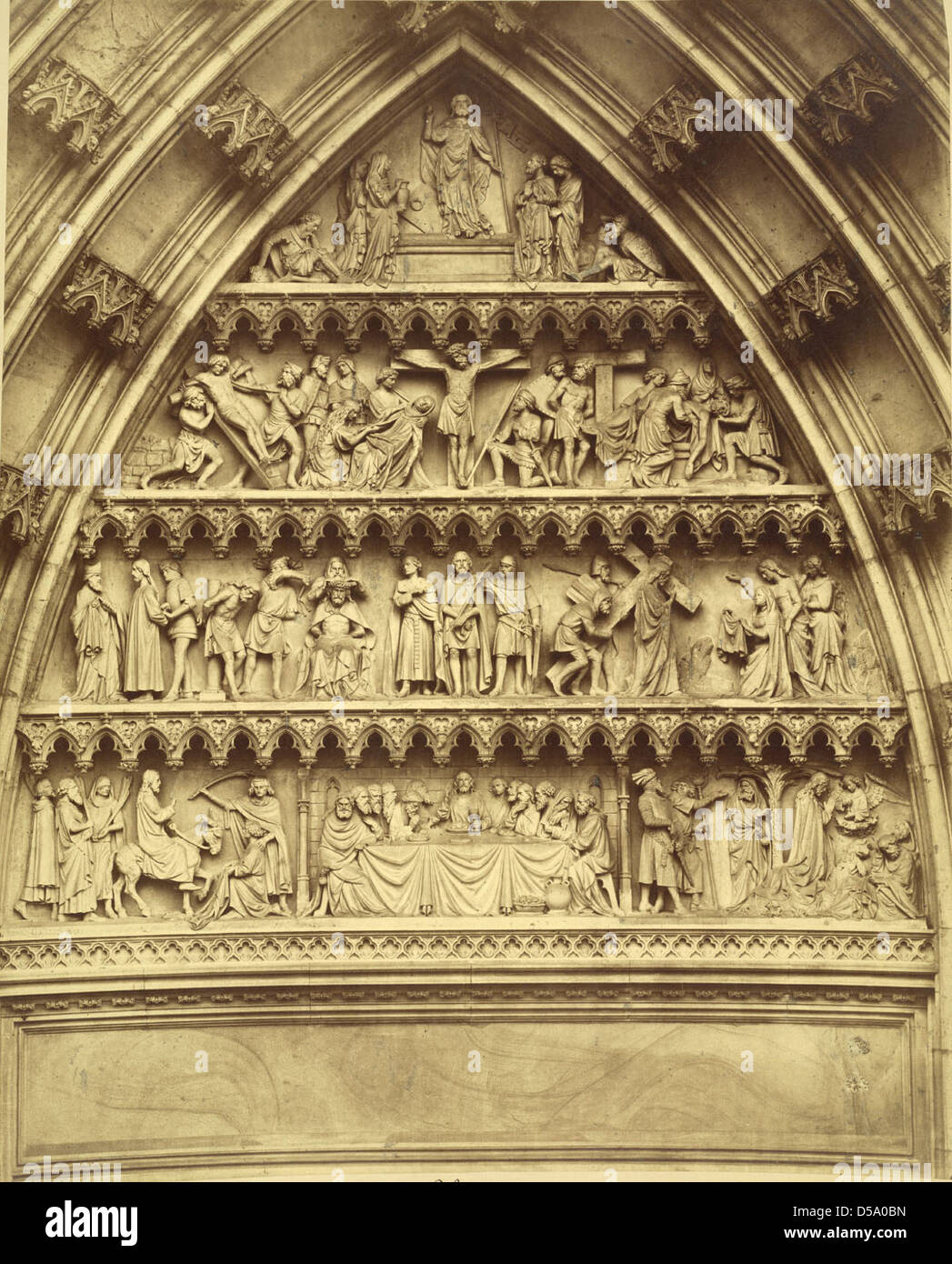 Le tympan et les archivoltes de la cathédrale de Cologne représentent des scènes de la dernière Cène et de la Crucifixion de Jésus-Christ. Les sculptures en relief trouvées ici font partie de l'imagerie religieuse complexe de la cathédrale, soulignant sa signification historique et spirituelle. Banque D'Images