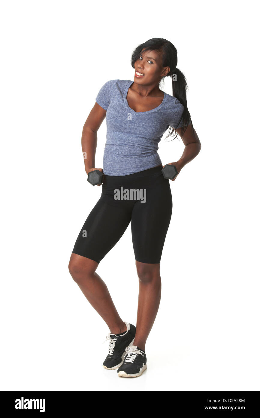 Jolie femme afro-américaine dans les vêtements de sport holding haltères. Banque D'Images
