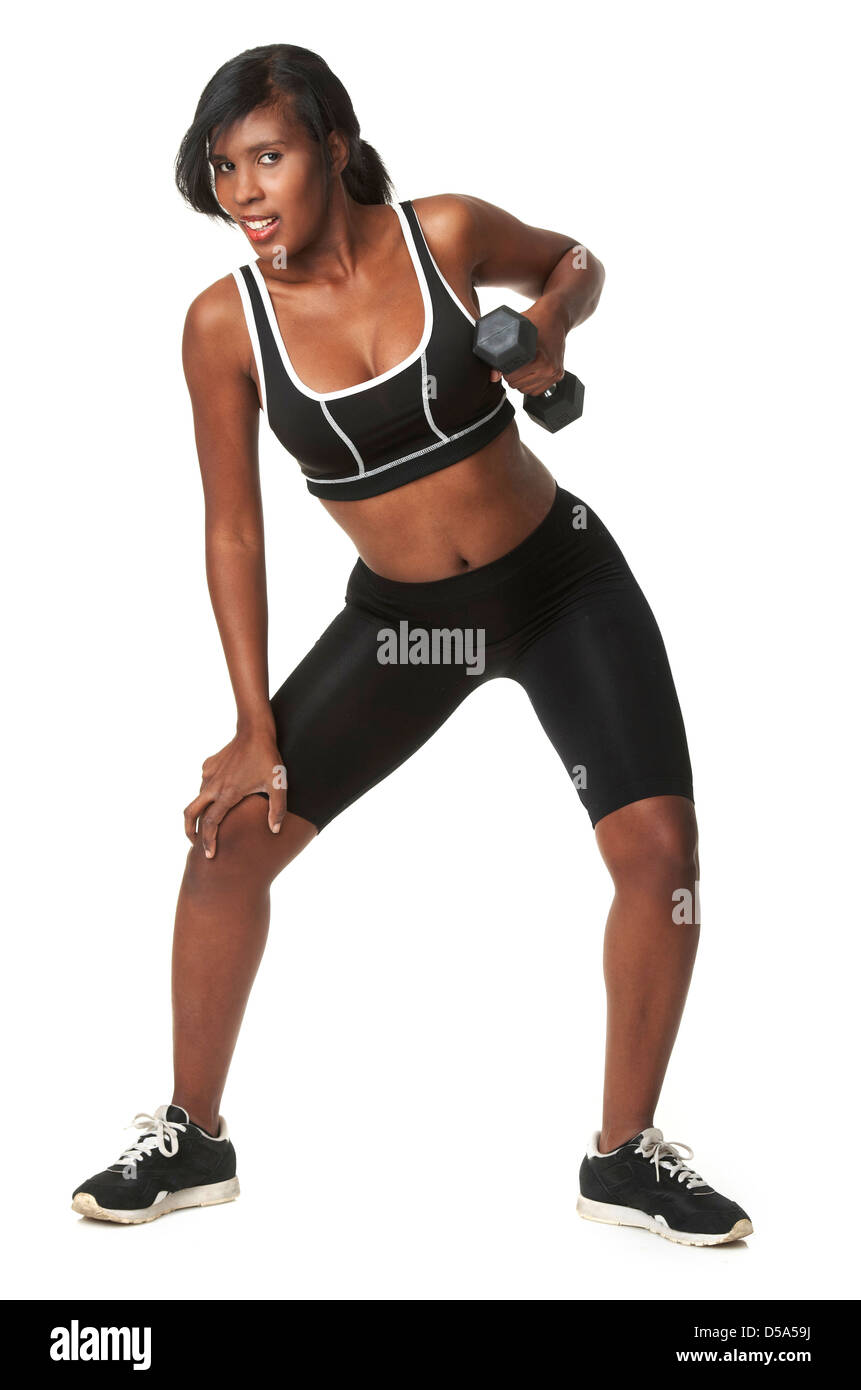 Jolie femme afro-américaine dans les vêtements de sport d'haltères de levage de poids. Banque D'Images