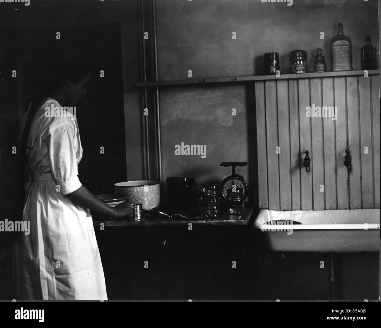 Une photographie illustrant le processus de mise en conserve, prise par Troie en 1912 pour le dépliant de l’école rurale. L'image fait partie d'une série sur la conservation des aliments et la nutrition à des fins éducatives. Banque D'Images