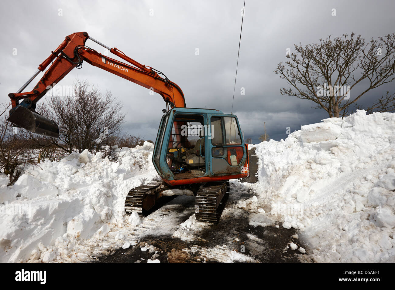 Compensation du tracteur country lane avec des dérives de la neige dans le comté d'Antrim en Irlande du Nord uk Banque D'Images
