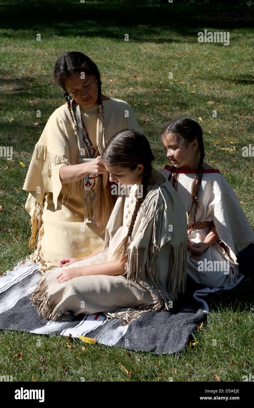 Un Native American Indian woman tressage des cheveux d'une jeune fille Banque D'Images