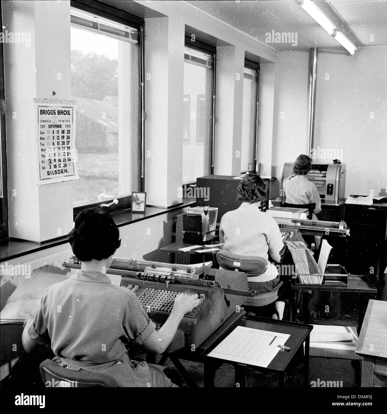 Tableau historique de l'Angleterre des années 60, des femmes qui travaillent dans un bureau à l'aide de télex ou de téléimprimeur machines. Banque D'Images