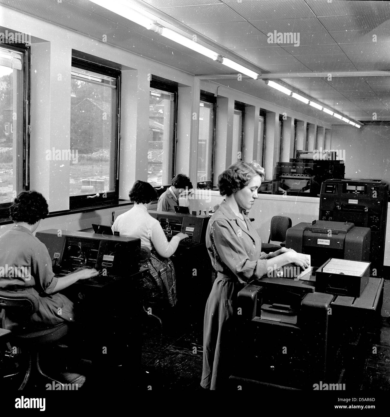 L'Angleterre. Photo historique de1960s de femmes travaillant dans un bureau à l'aide d'un grand les télex. Banque D'Images
