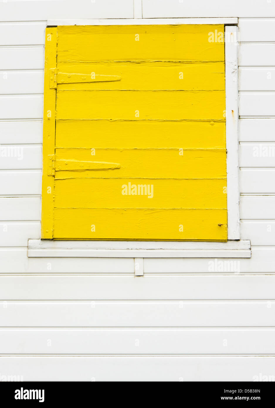 Volets fermés jaune vif sur fond blanc beach hut. Banque D'Images