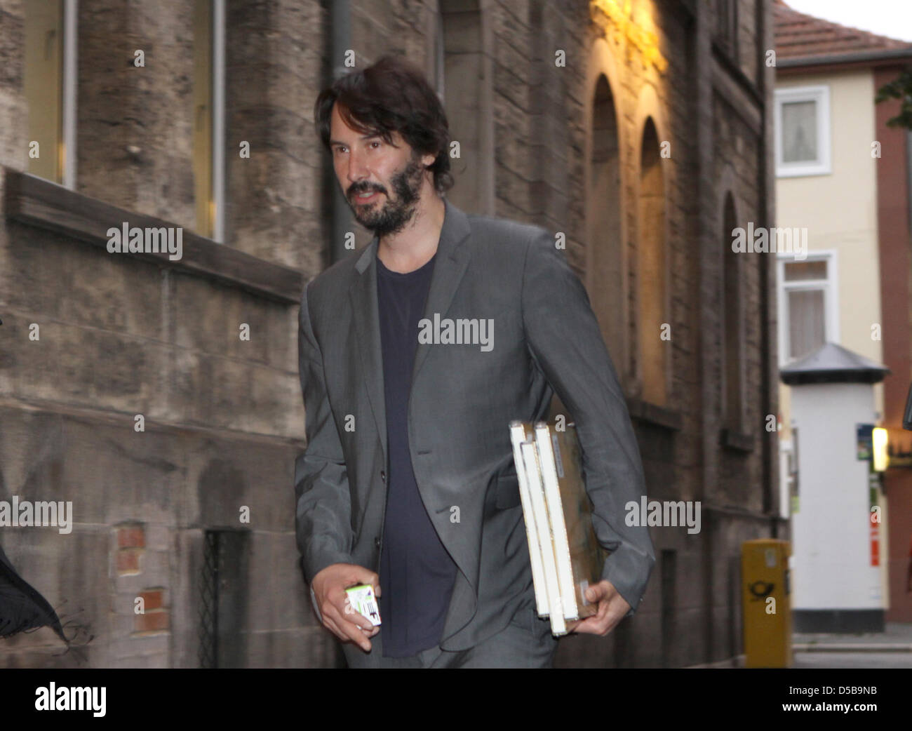 L'acteur canadien Keanu Reeves se dirige vers l'Hotel Gebhards en portant le livre 'je vois avec mon petit Œil, quelque chose commençant par S' à Goettingen, Allemagne, 13 août 2010. Selon les informations publiées par la NDR-online, Reeves séjourné à Goettingen de parler d'un projet de livre avec la maison d'édition de vécu. Photo : Sebastian Mauritz Banque D'Images