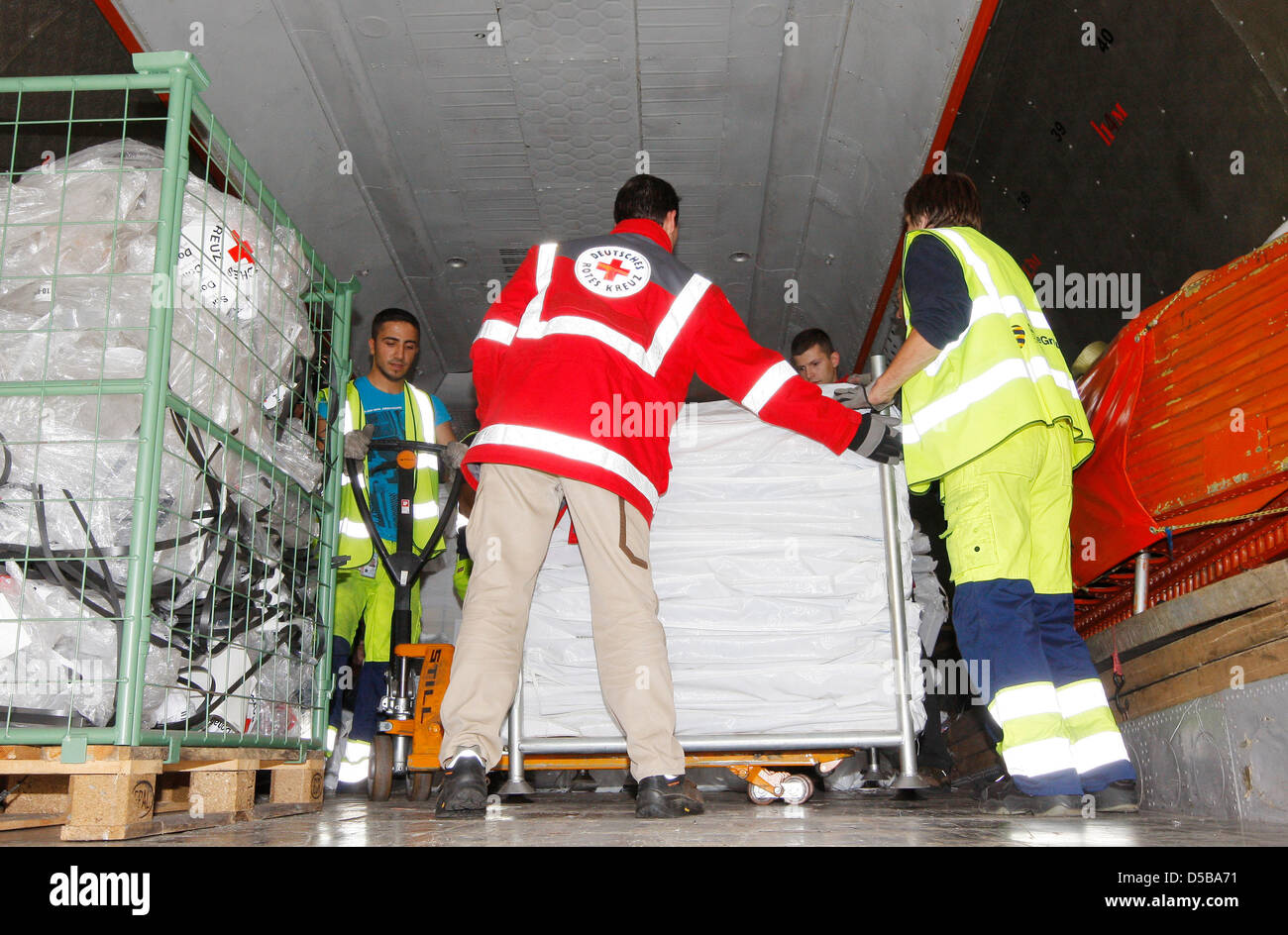 Le personnel de la Croix-Rouge allemande et charge les employés de l'aéroport de secours dans un avion Antonov à l'aéroport de Schönefeld, Allemagne, 17 août 2010. L'avion va livrer 18 tonnes d'aide humanitaire au Pakistan, qui souffre d'une inondation massive. Photo : Nestor Bachmann Banque D'Images