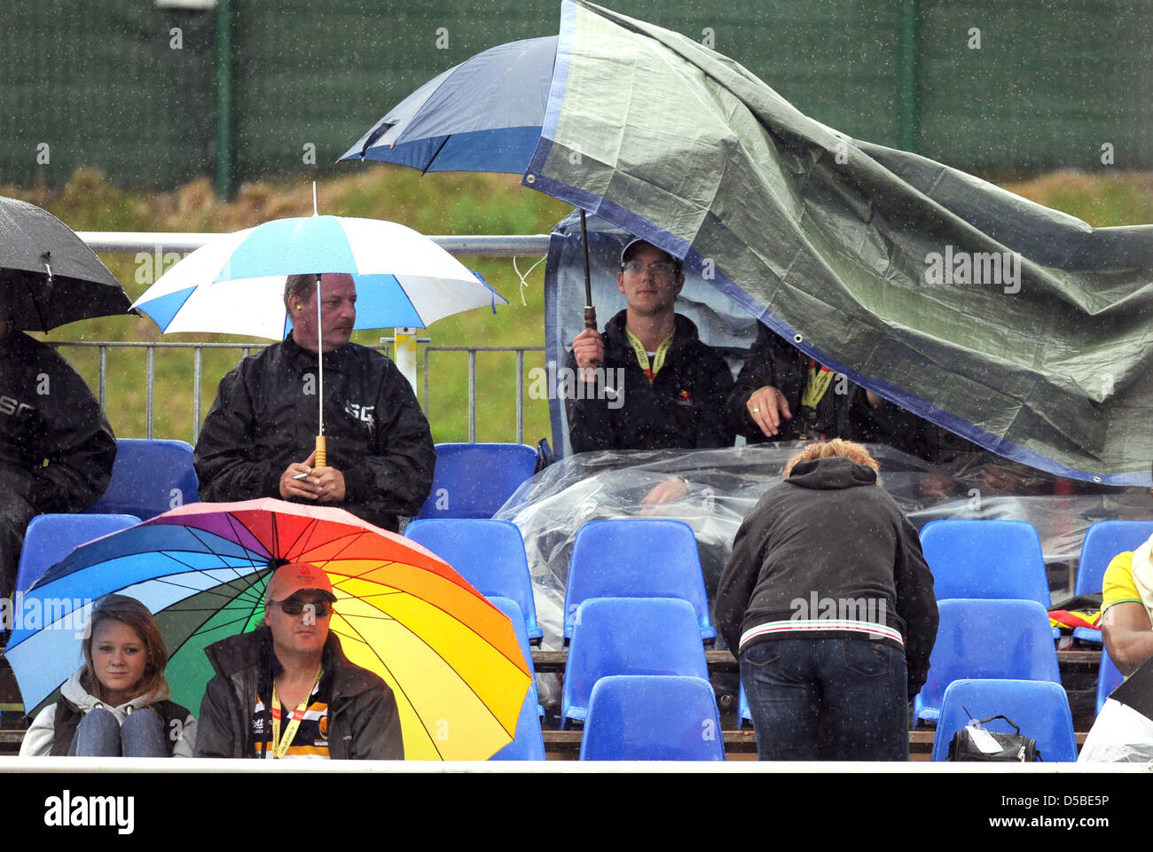 Spectateurs stand in the rain à la piste de course au cours de la troisième session d'essais au circuit de Spa-Francorchamps près de Spa, Belgique, 28 août 2010. La Formule 1 2010 Grand Prix de Belgique est tenue le 29 août 2010. Photo : Peter Steffen Banque D'Images