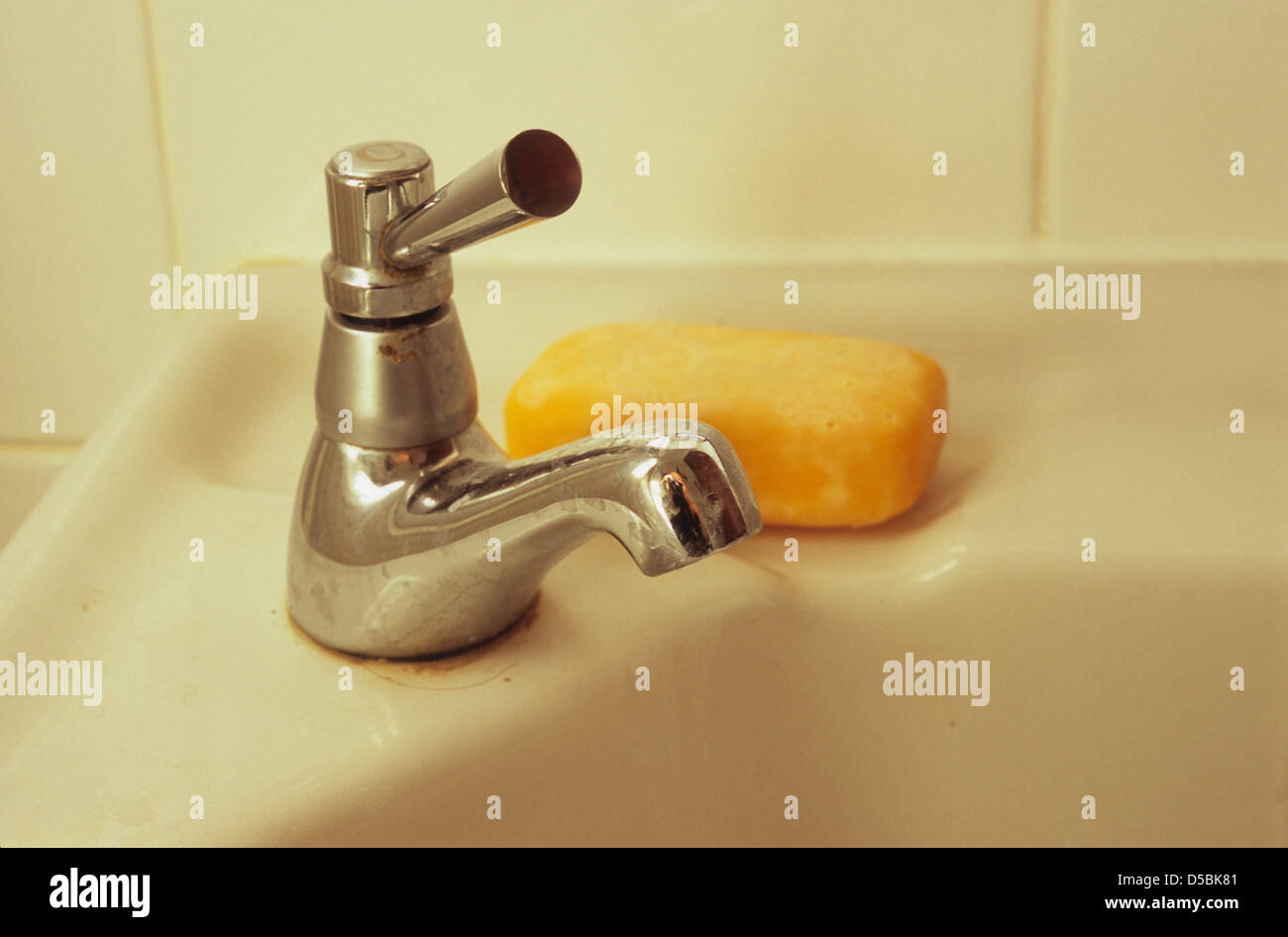 Détail de salle de bain évier avec robinet avec levier de vitesse et le bar de savon orange Banque D'Images