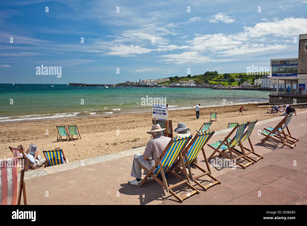 Transats sur la plage et la promenade à Swanage dans le Dorset England UK Banque D'Images