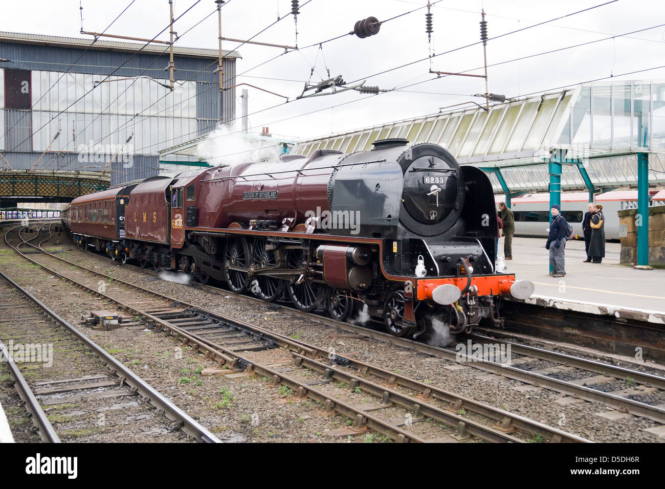 Une locomotive à vapeur tirant un train de voyageurs sur la ligne principale à Carlisle, Angleterre Banque D'Images