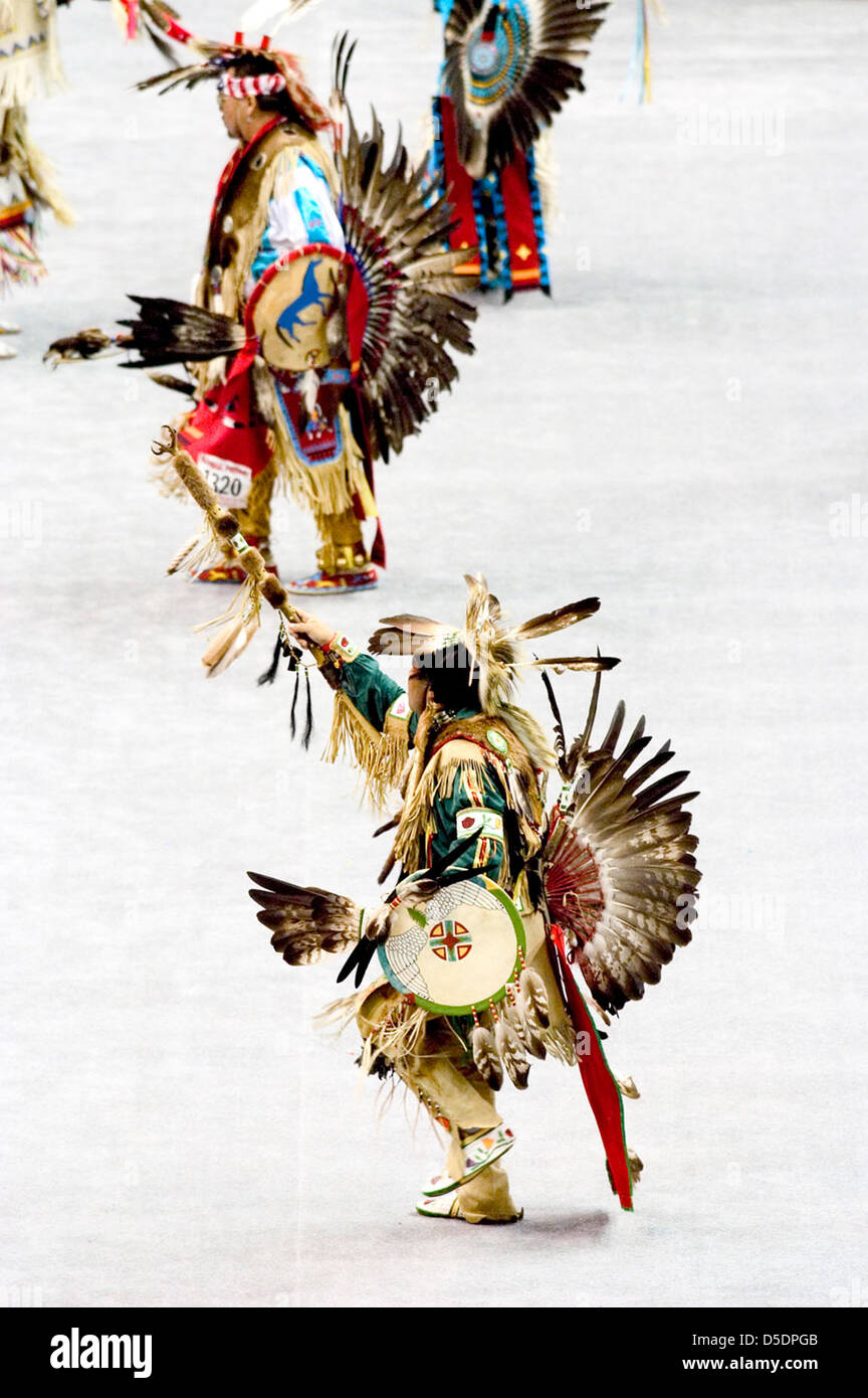 Cette image montre une cérémonie de pow-wow amérindien en plein essor, avec des danseurs en robe de cérémonie et coiffes. Le rassemblement comprend des chants traditionnels, des danses et des expressions spirituelles représentant les rituels culturels autochtones. Banque D'Images