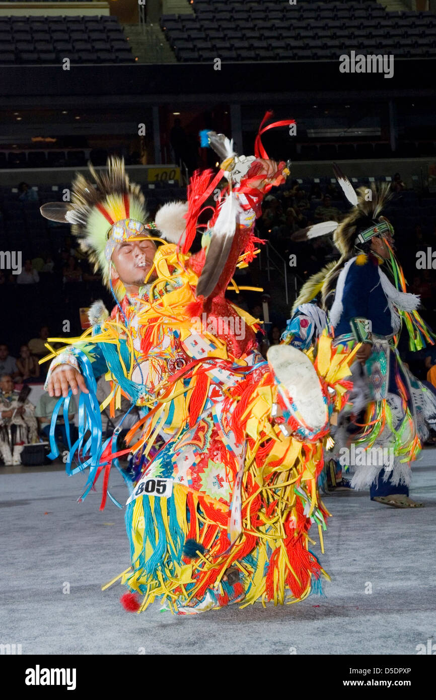Une photographie de 2007 du National Museum of the American Indian, montrant un jeune homme amérindien participant à un pow-wow. L'homme est habillé dans une tenue traditionnelle vibrante, effectuant une danse cérémonielle. Banque D'Images
