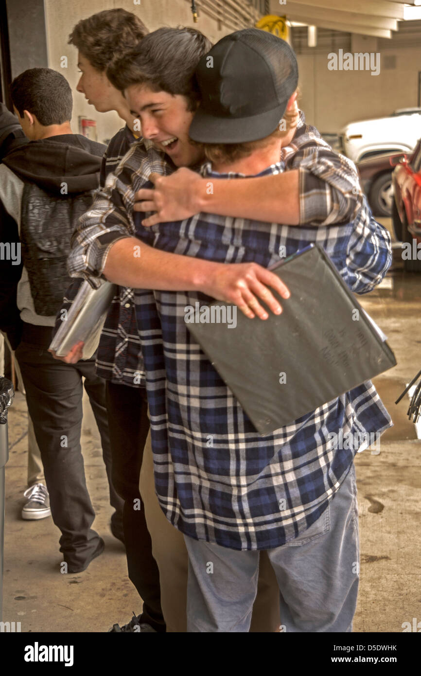 Homme enthousiaste high school auto shop hug étudiants après la classe à San Clemente, CA. Banque D'Images