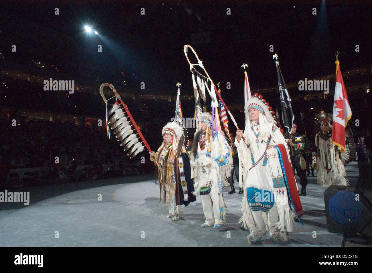 Le Powwow de 2005 au Musée national des Indiens d'Amérique présente l'entrée grandiose des tribus amérindiennes, avec les participants vêtus de regalia traditionnels. Le drapeau canadien est bien en vue, soulignant l'inclusion des Premières Nations dans la célébration culturelle. Cet événement est une expression puissante de l'héritage amérindien. Banque D'Images