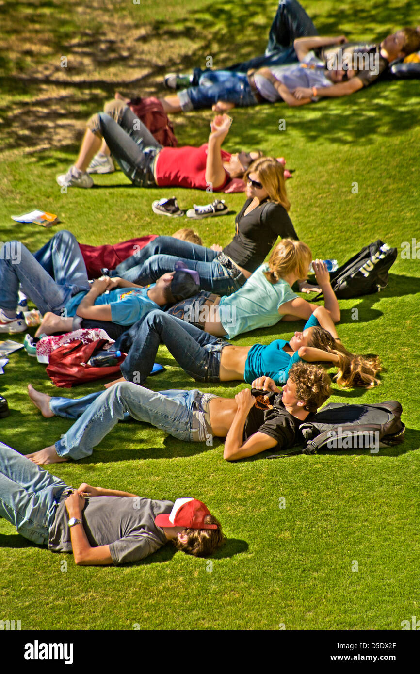 Un groupe de jeunes adultes de soleil sur une pelouse, à Los Angeles. Dans de telles conditions météorologiques de l'écran solaire est nécessaire pour éviter les brûlures Banque D'Images