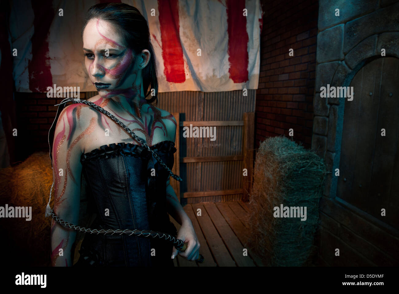 Femme avec des tatouages et de whip en allée teinté Banque D'Images