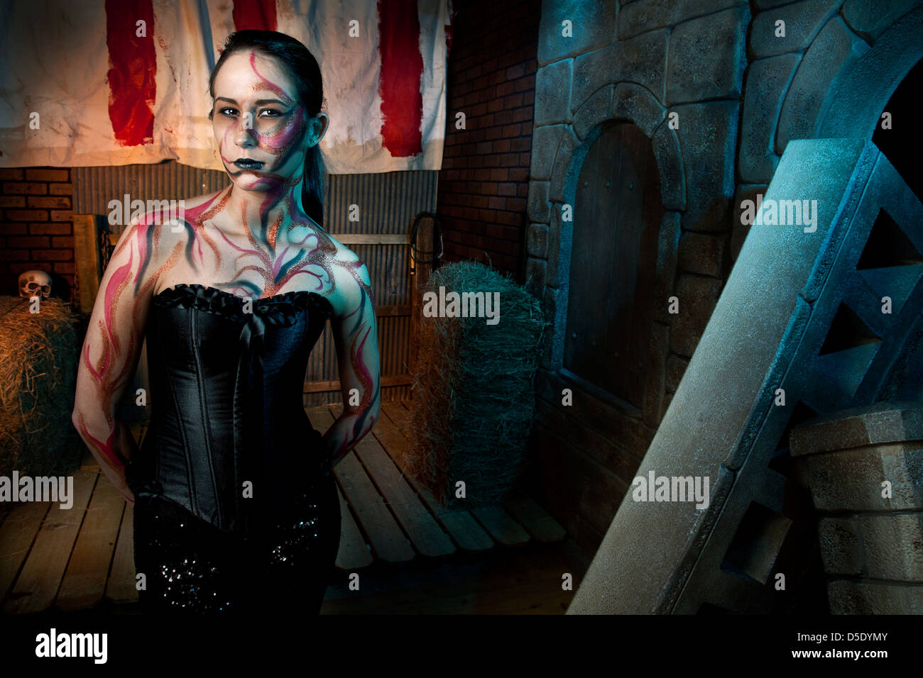 Femme en Corset de cuir et de tatouages en face de tented alley Banque D'Images