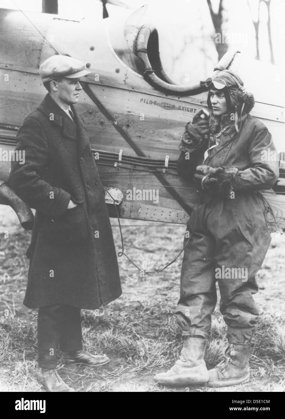 Une photographie de 1922 du pilote de poste Jack Knight, avec un individu non identifié, capturée devant un biplan D.H.4 de Havilland. Knight fut l'un des premiers pilotes de la poste aérienne américaine, jouant un rôle déterminant dans le développement des services postaux aériens. Banque D'Images