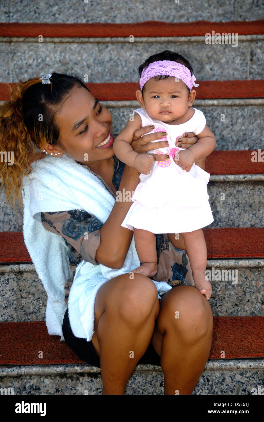 Jeune maman et bébé assis sur les marches du temple à Udon Thani Thaïlande prises le 20/09/2010 Banque D'Images