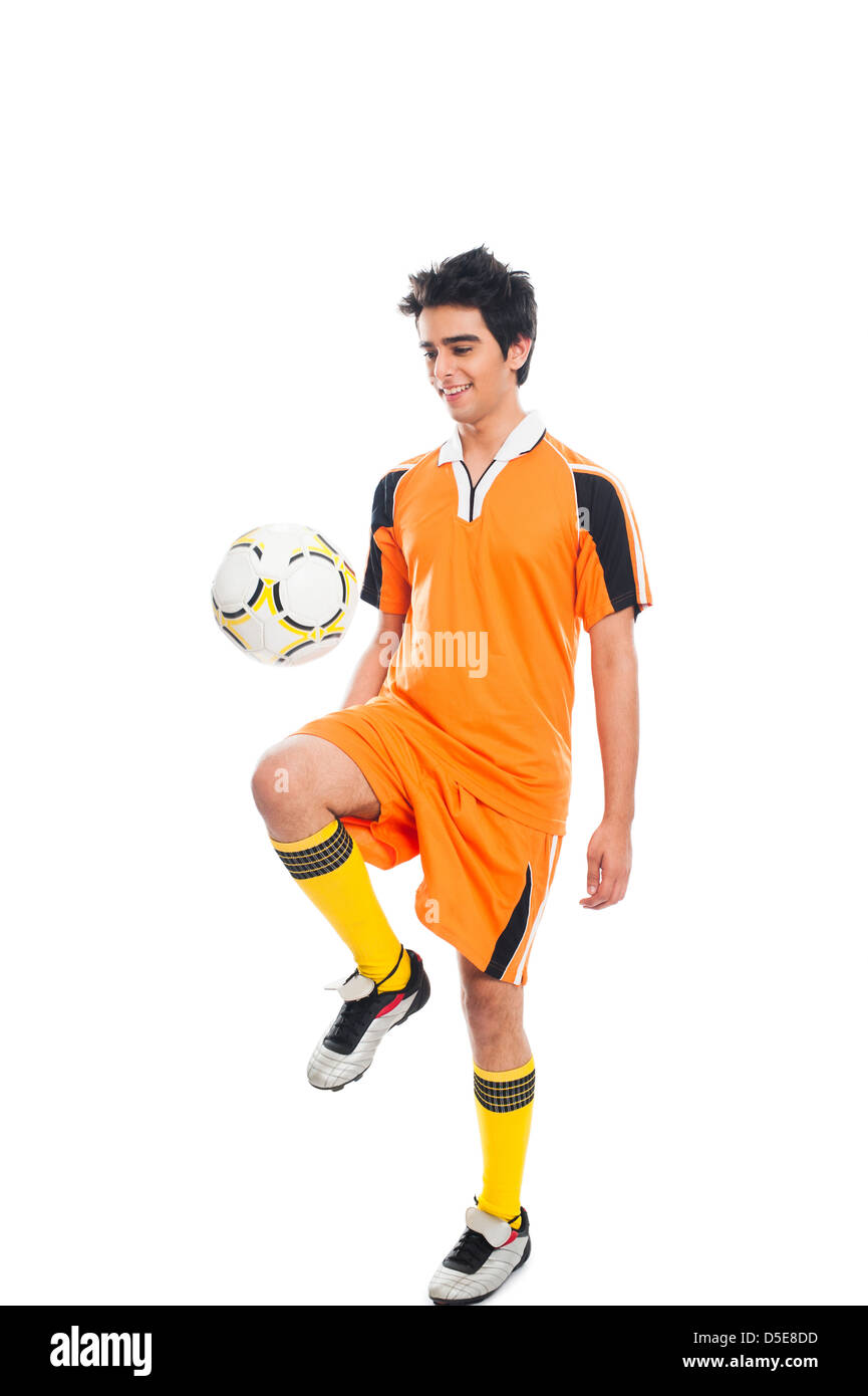 Joueur de foot en pratiquant avec un ballon de foot Banque D'Images