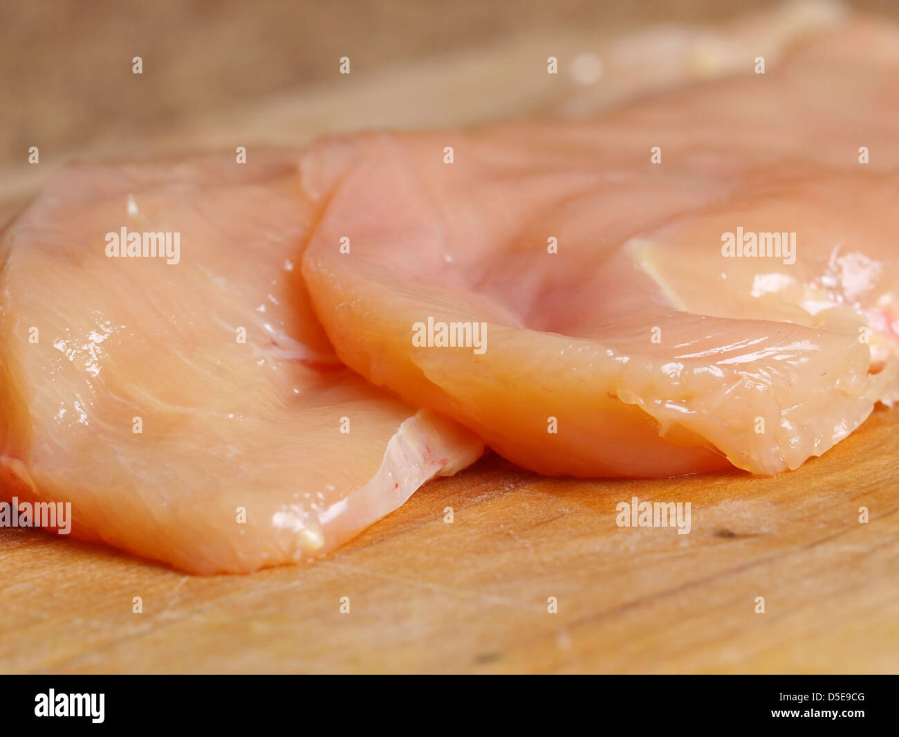 Filets de poulet sur une planche en bois Banque D'Images