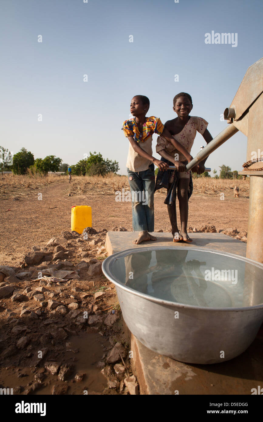 Les enfants de tirer de l'eau d'un puits à proximité du village de Nandom, dans le nord du Ghana. Banque D'Images