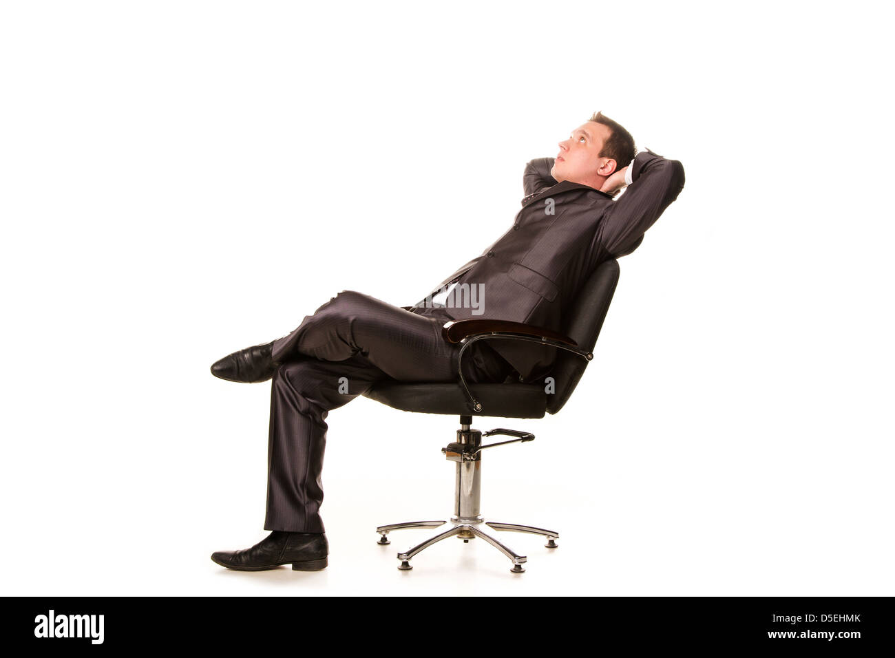 Confiant smiling young woman relaxing on a chair isolated on white Banque D'Images