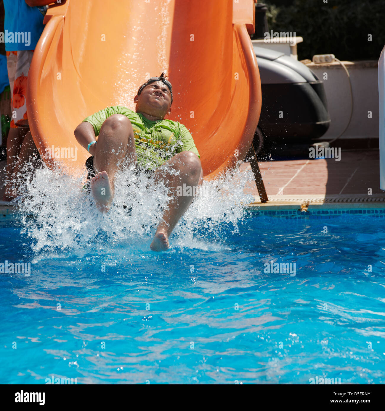 Adolescent profitant d'une glissade d'eau dans une piscine extérieure. Village de Torba, péninsule de Bodrum, Turquie. Banque D'Images