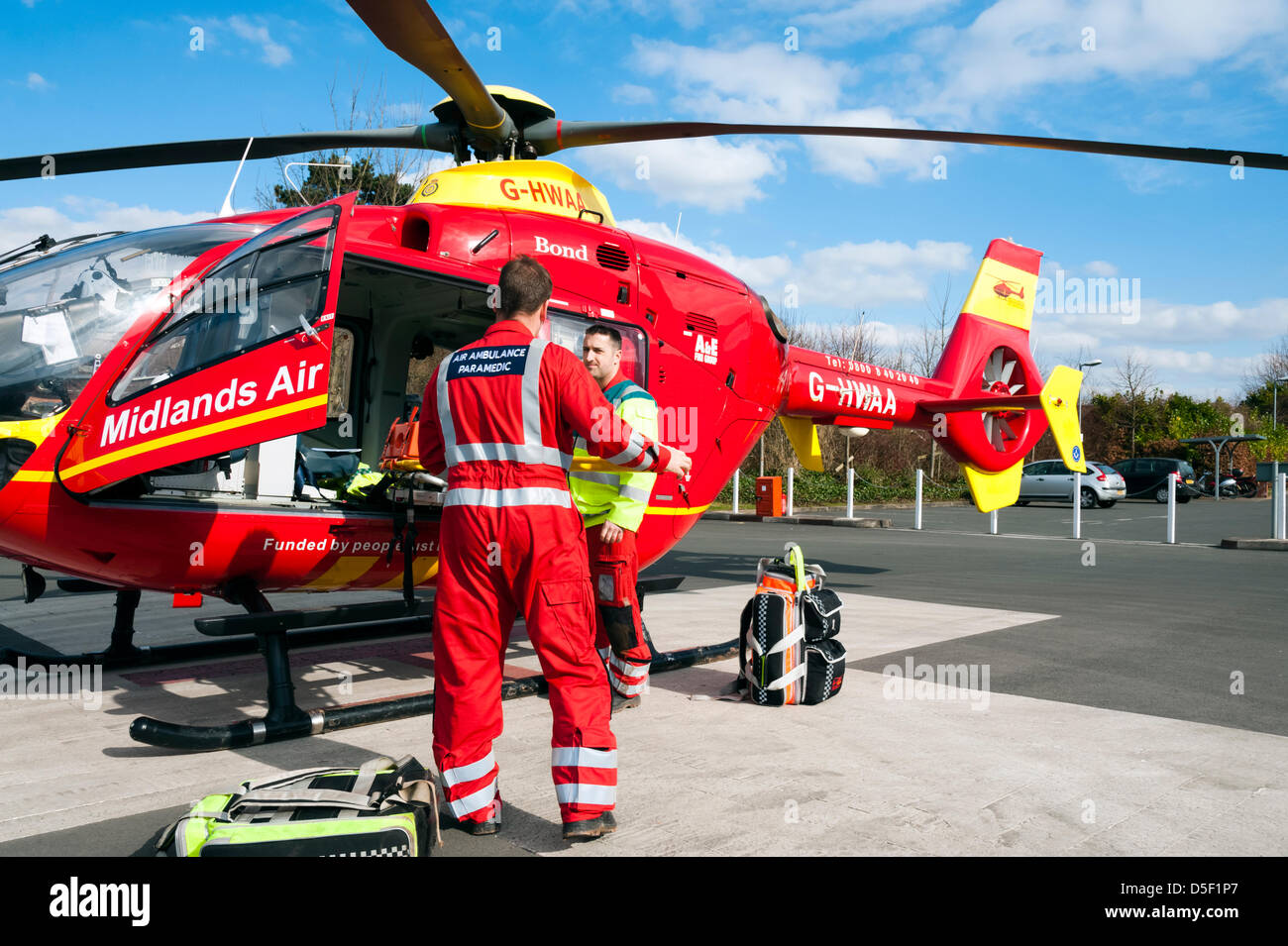 Midlands Air Ambulance a atterri dans le parking de l'hôpital à Hereford. Air Ambulance ambulancier ranger la civière retour à bord de l'hélicoptère. Banque D'Images