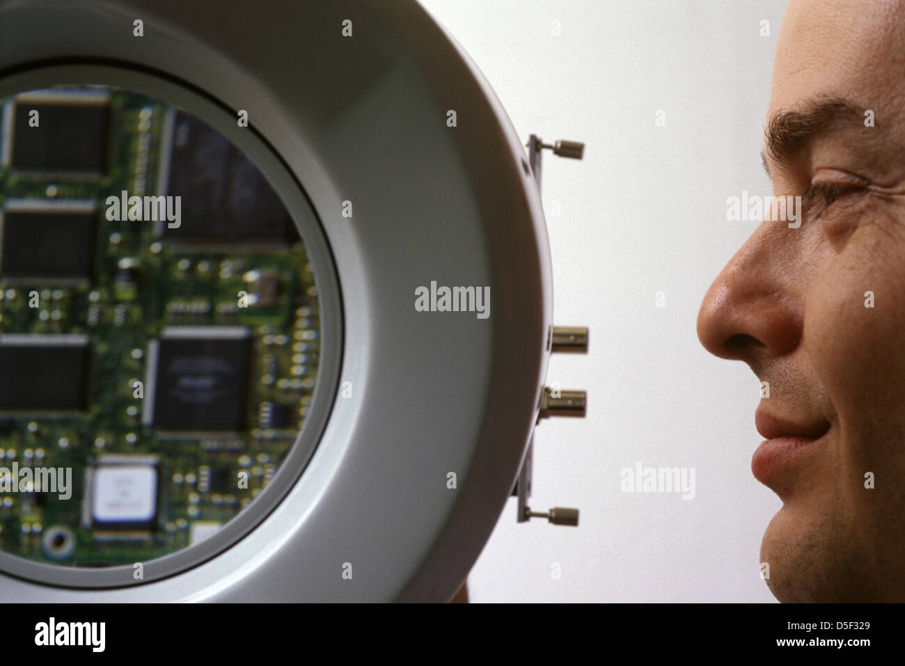 Un technicien israélien avec détail des composants sur le circuit électrique imprimé conseil dans une entreprise de haute technologie en Israël Banque D'Images
