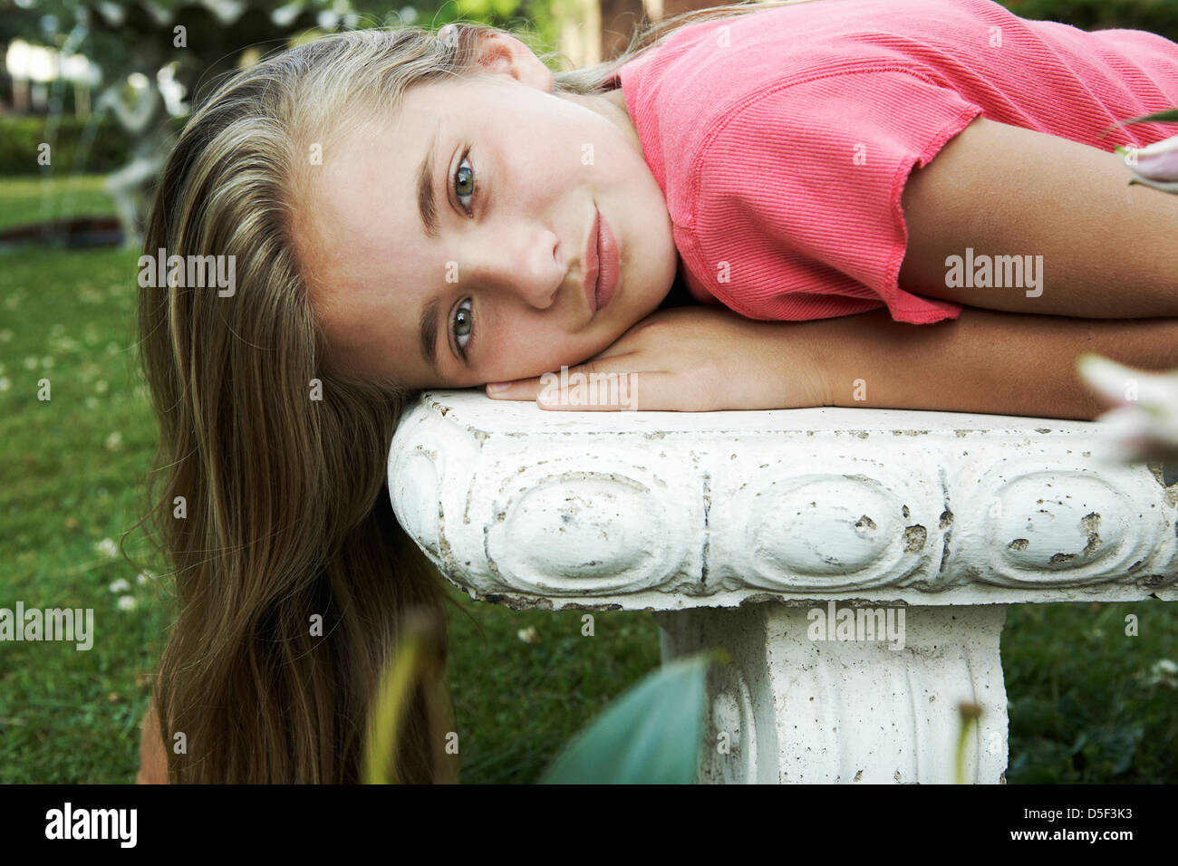 Tween magnifique couché sur banc de jardin Banque D'Images