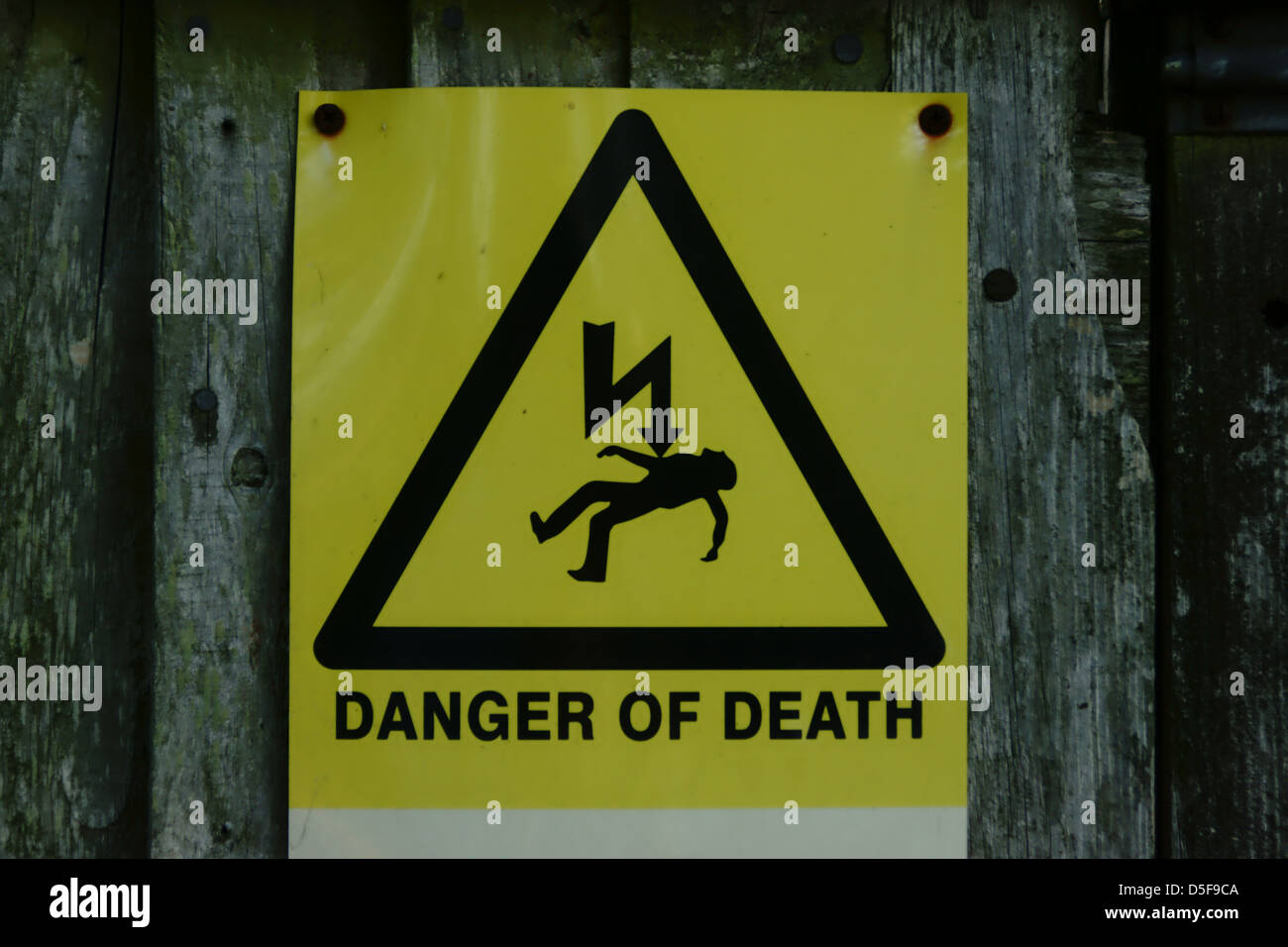 Danger de mort flèche jaune clou rouillé bois sign Banque D'Images