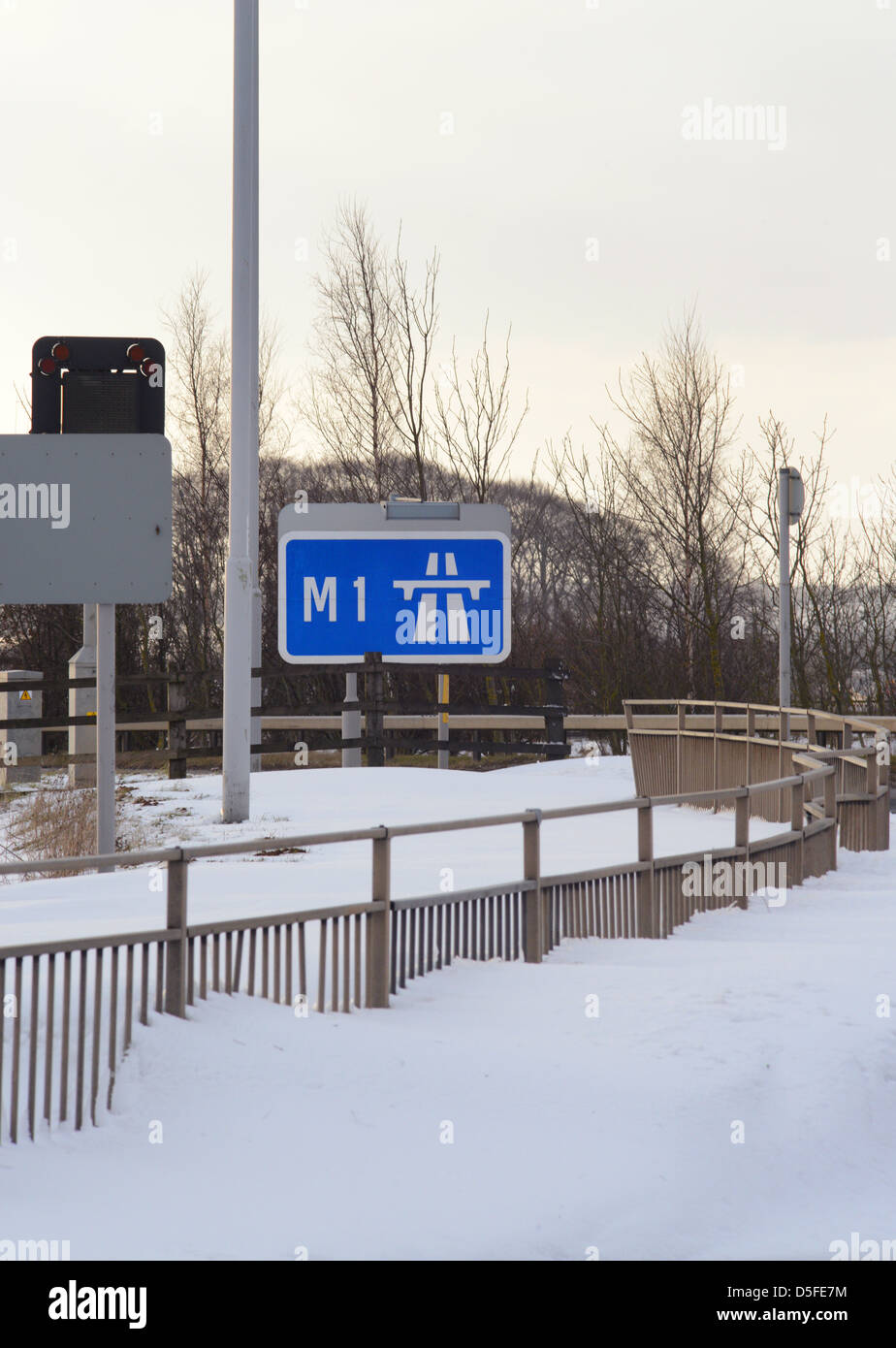 Début de l'autoroute M1 signe entouré par des amoncellements de neige géante près de Leeds Yorkshire royaume uni Banque D'Images